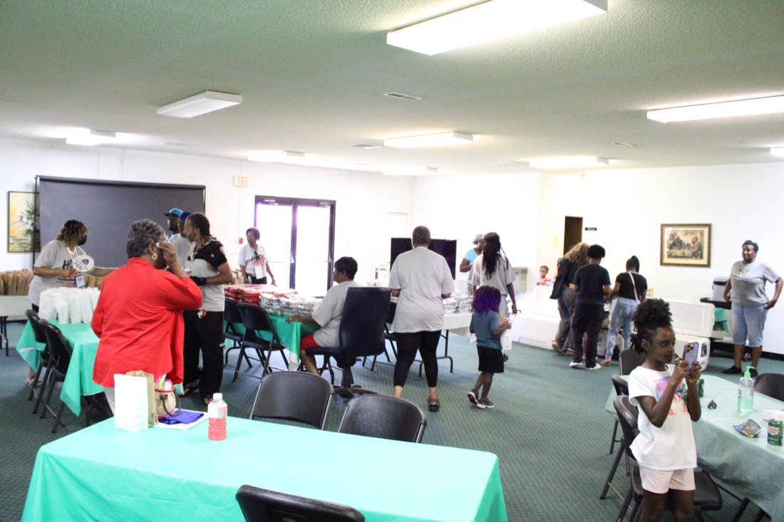 Families gathered at tables inside the fellowship hall